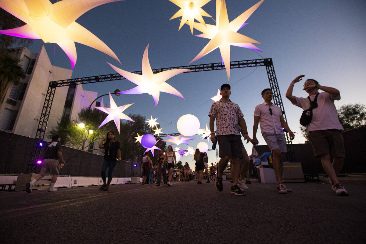 Attendees walk under an art installation during the Life is Beautiful festival on Sunday, Sept. ...