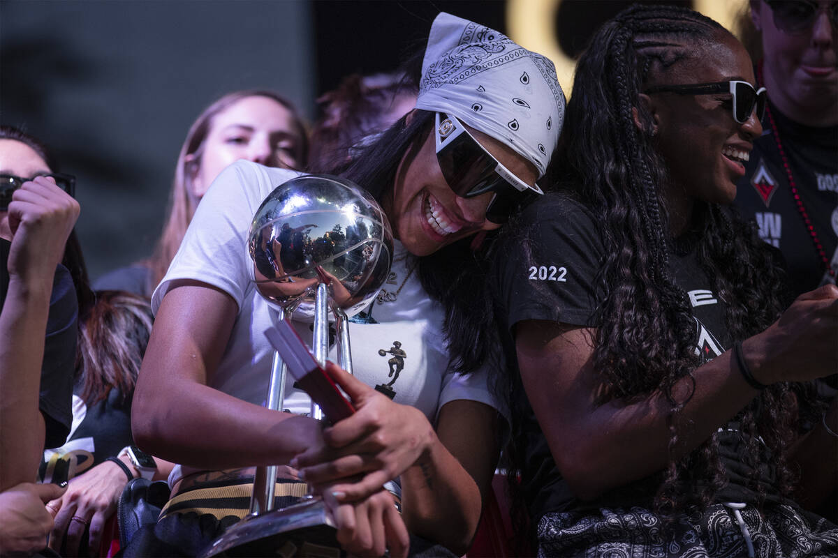 Las Vegas Aces forward A'ja Wilson laughs with guard Jackie Young while holding the 2022 WNBA C ...