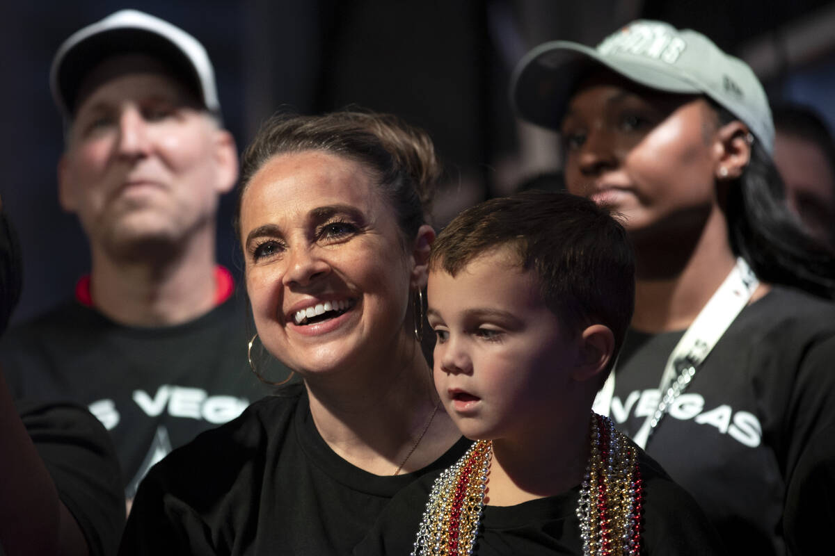 Las Vegas Aces head coach Becky Hammon, holding her son Sam Hammon, beams as A’ja Wilson ...