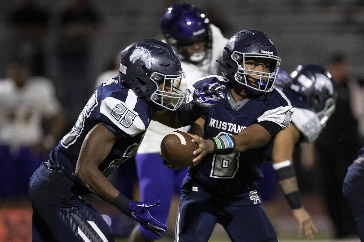 Shadow Ridge quarterback Coen Coloma (8) hands the ball off to running back JaQuieze Holland (2 ...