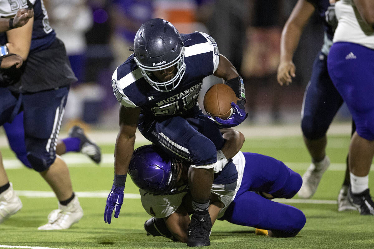 Shadow Ridge running back JaQuieze Holland (25) is tackled by Durango offensive linebacker Maso ...