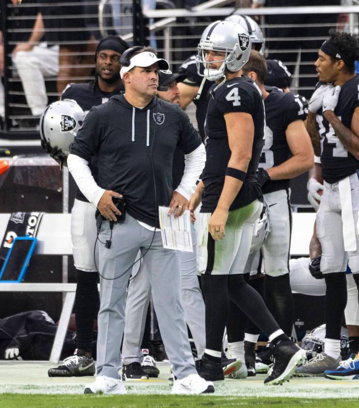 Las Vegas Raiders quarterback Derek Carr (4) and head coach Josh McDaniels watch the game from ...