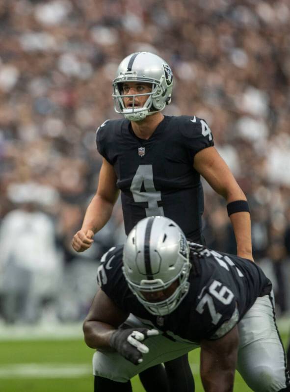 Raiders quarterback Derek Carr (4) surveys the field with Raiders guard John Simpson (76) set o ...
