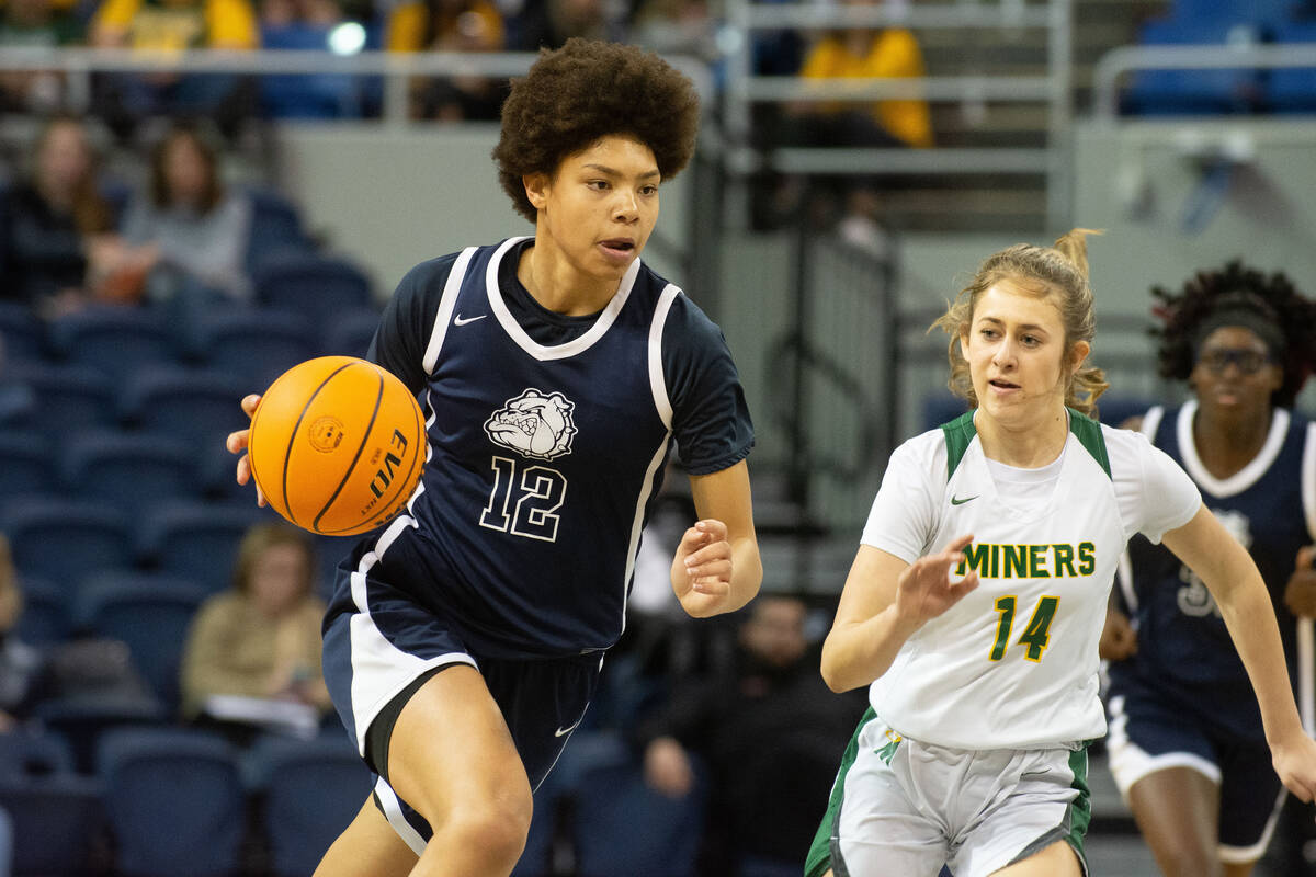 Montaya Dew of Centennial High School dribbles past Bishop Manogue defender Anna Alonso during ...