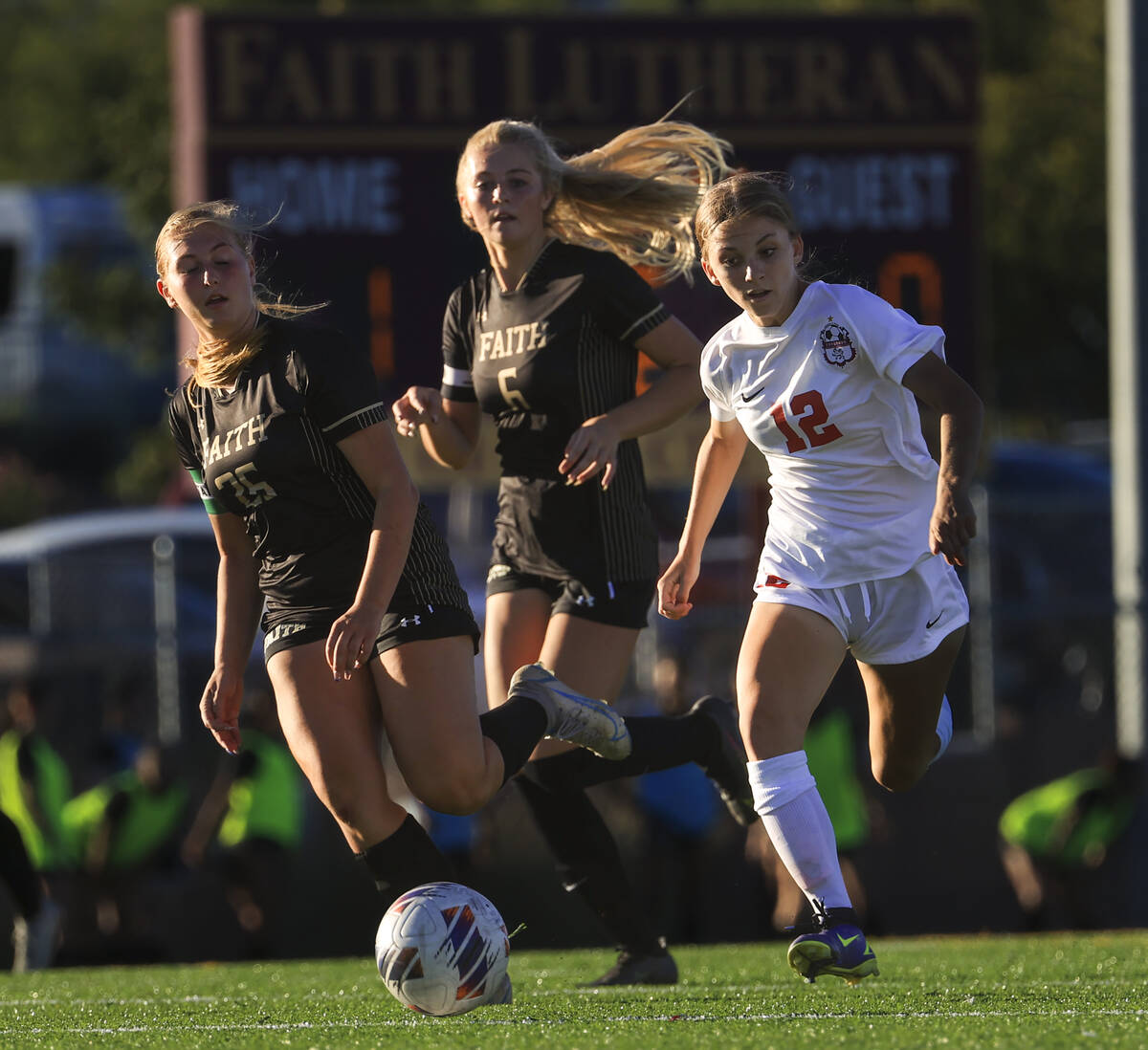 Faith Lutheran's Taylor Folk (26) and an unidentified player chase after the ball against Coron ...
