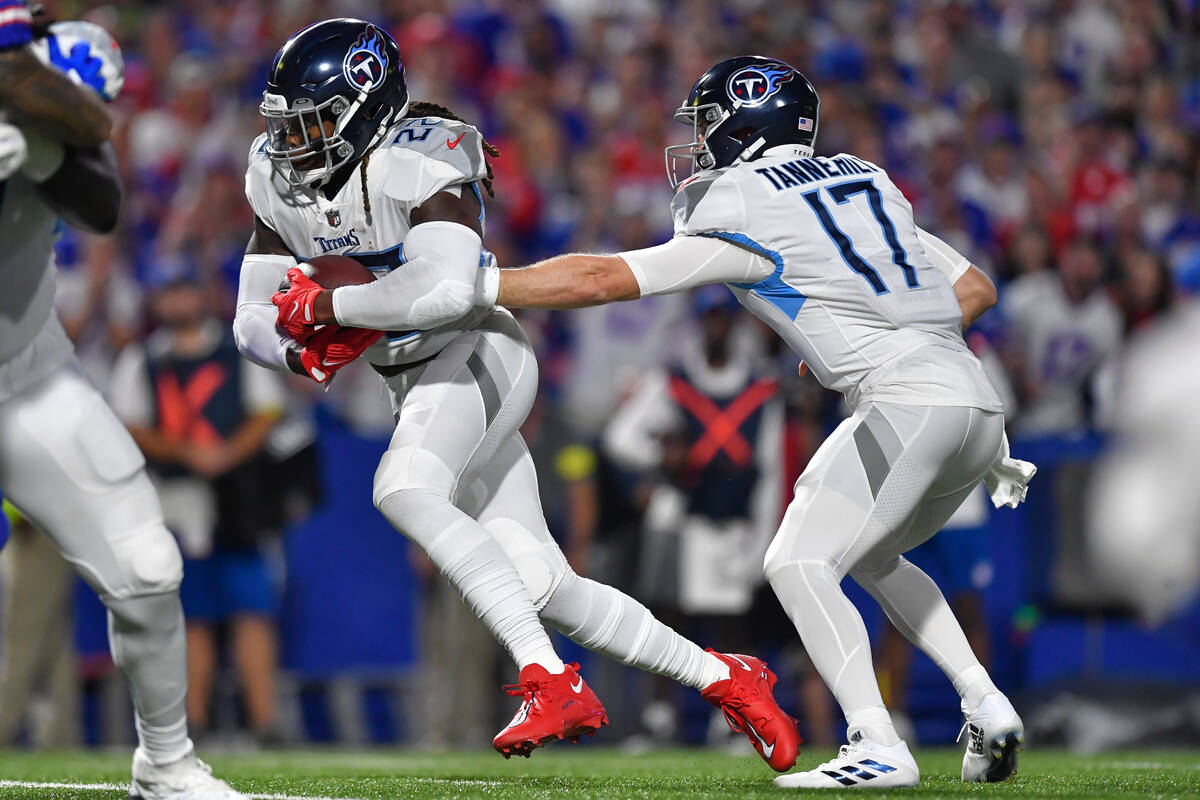 Tennessee Titans running back Derrick Henry, left, takes a handoff from quarterback Ryan Tanneh ...