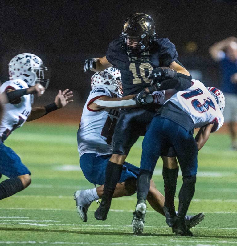 Faith Lutheran's wide receiver Peyton Steigerwald (10) is taken down by Liberty defenders inclu ...