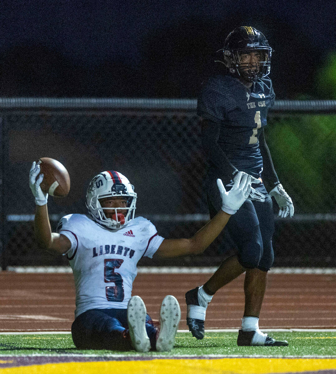 Liberty wide receiver Landon Bell (5) signals a touchdown pass over Faith Lutheran's cornerback ...