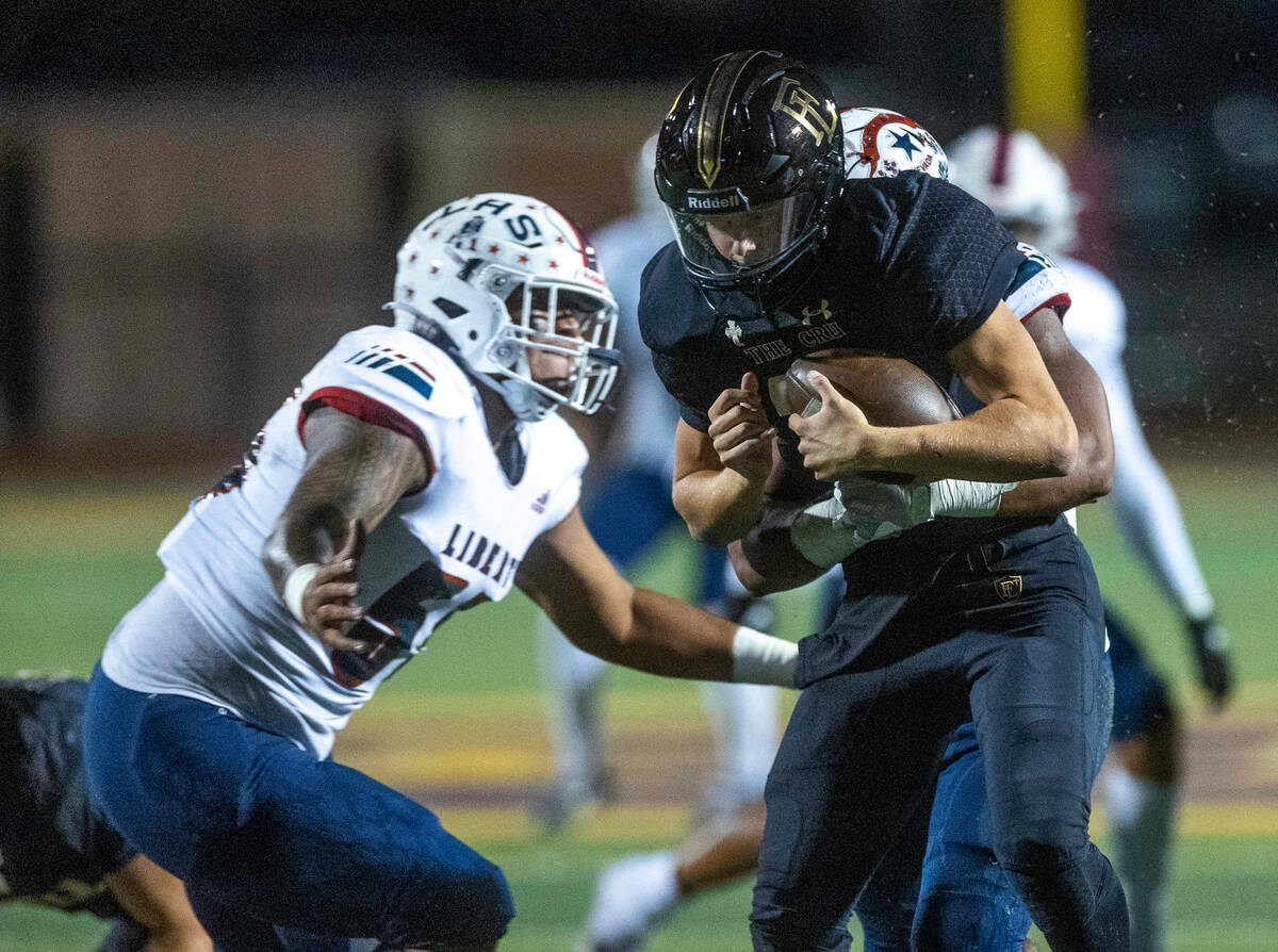 Faith Lutheran's quarterback Rylan Walter (13) is sacked by the Liberty defense including defen ...