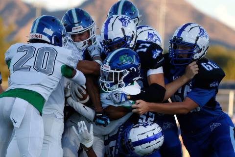 Green Valley High's wide receiver Angel Merino (1) is sandwiched by Basic High defense during t ...