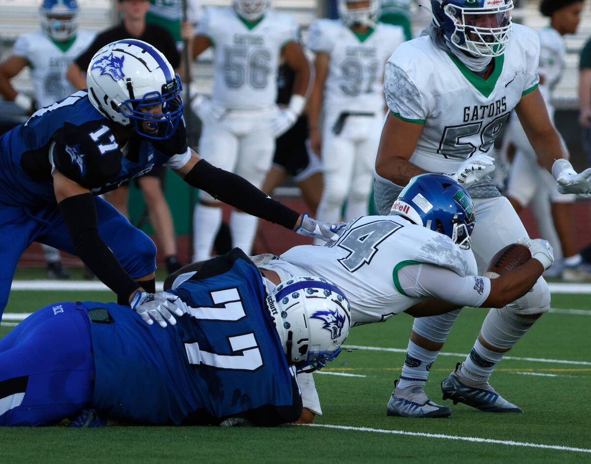 Green Valley High's running back Estaban Martinez (34) is sucked by Basic High's guard Domingo ...