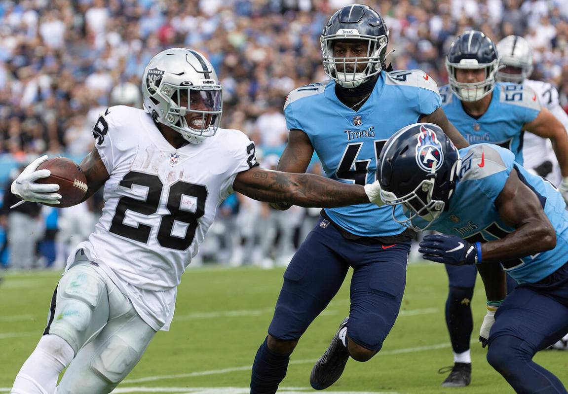 Raiders running back Josh Jacobs (28) stiff arms Tennessee Titans cornerback Roger McCreary (21 ...