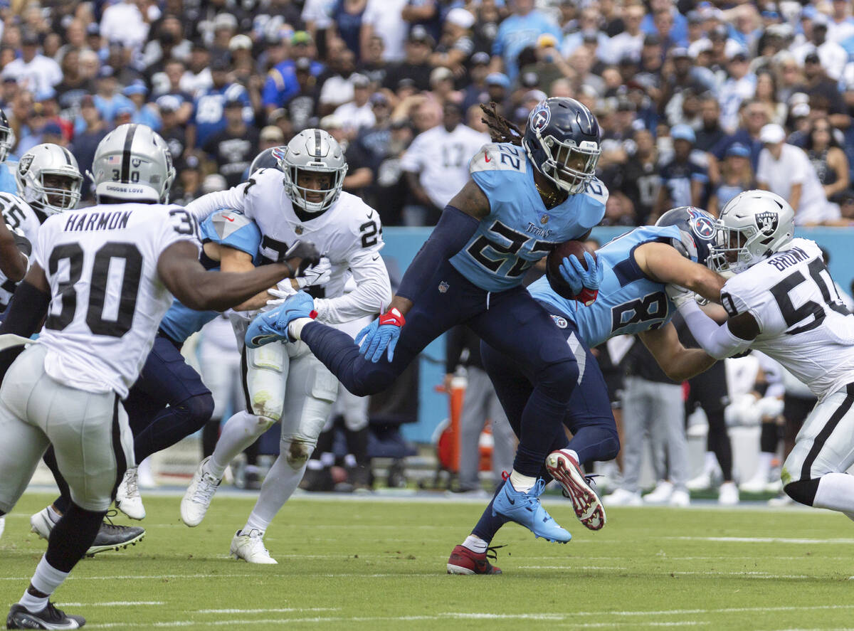 Tennessee Titans running back Derrick Henry (22) leaps through a hole past Raiders safety Duron ...