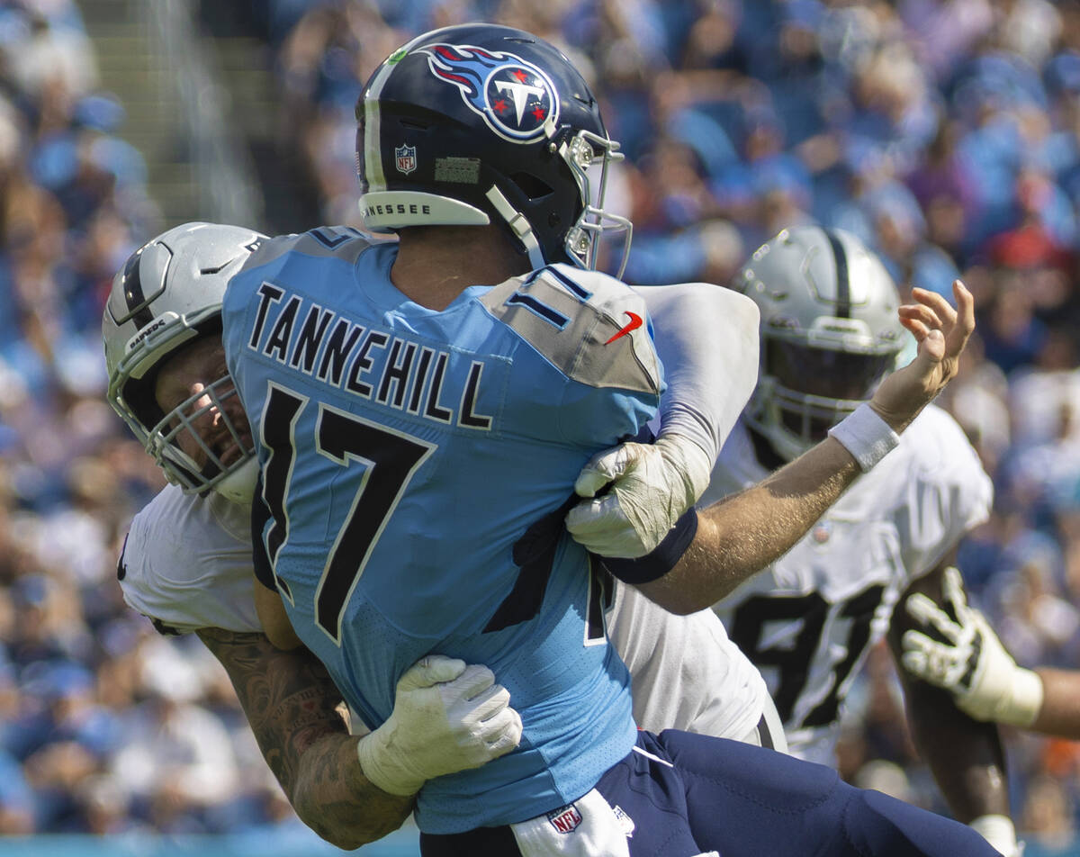 Raiders defensive end Maxx Crosby (98) tackles Tennessee Titans quarterback Ryan Tannehill (17) ...