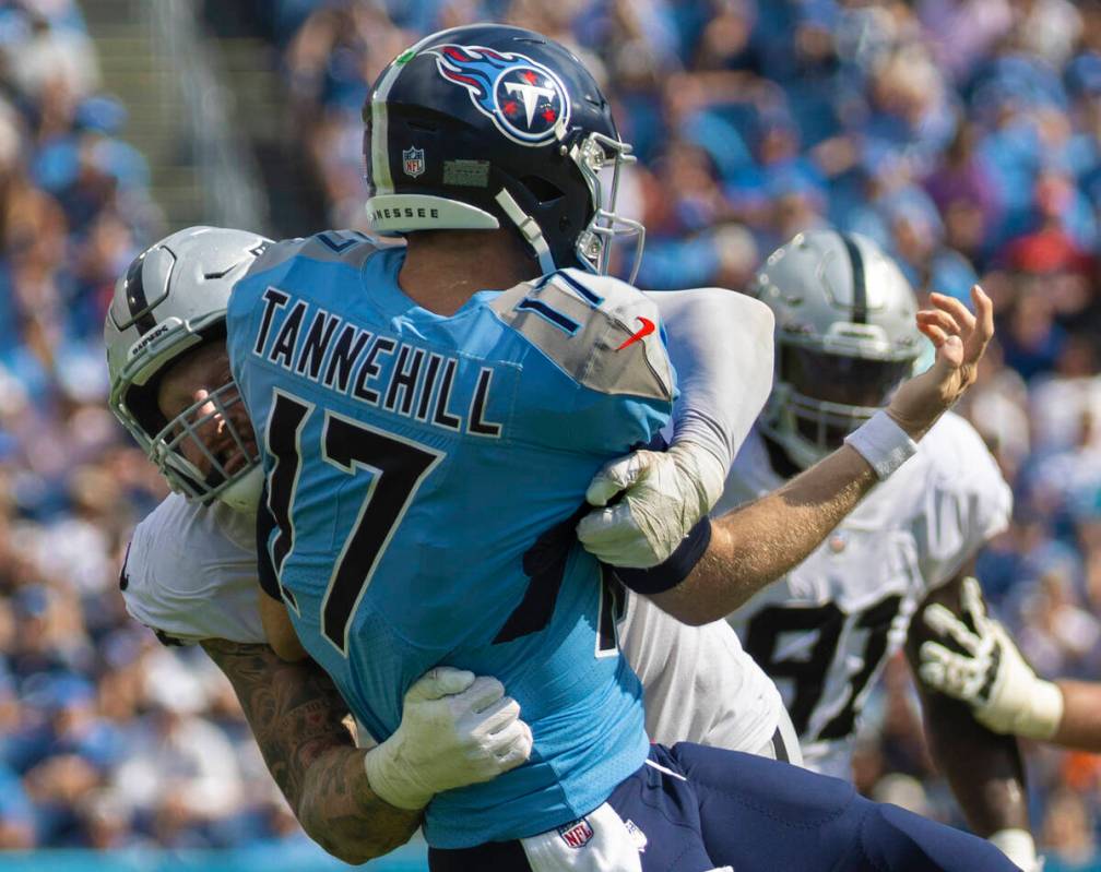 Raiders defensive end Maxx Crosby (98) tackles Tennessee Titans quarterback Ryan Tannehill (17) ...