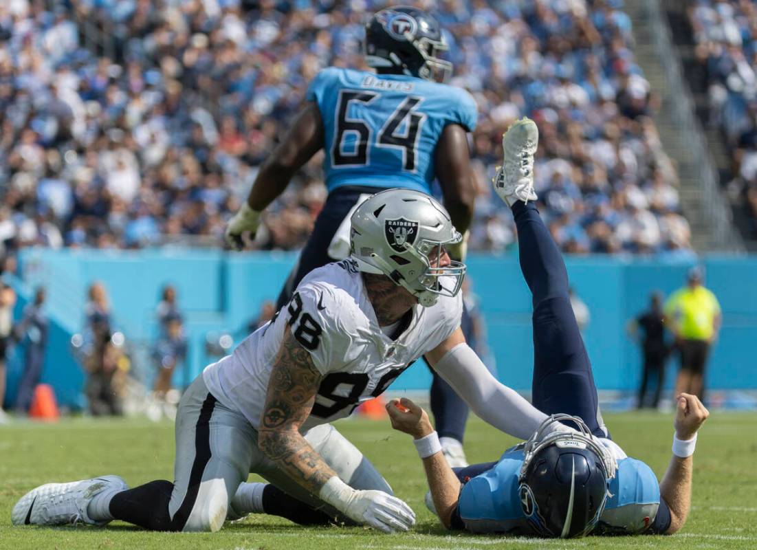 Raiders defensive end Maxx Crosby (98) tackles Tennessee Titans quarterback Ryan Tannehill (17) ...