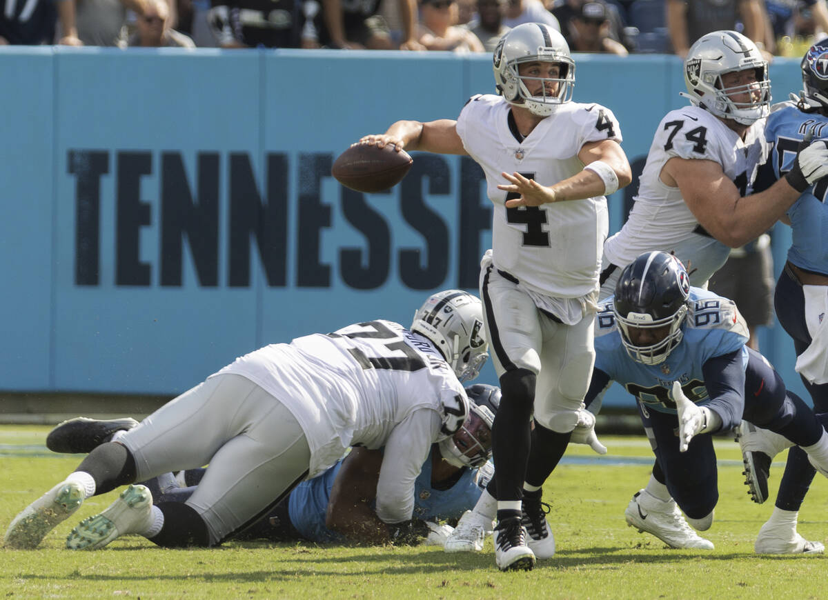 Raiders quarterback Derek Carr (4) gets a pass away under pressure from Tennessee Titans defens ...