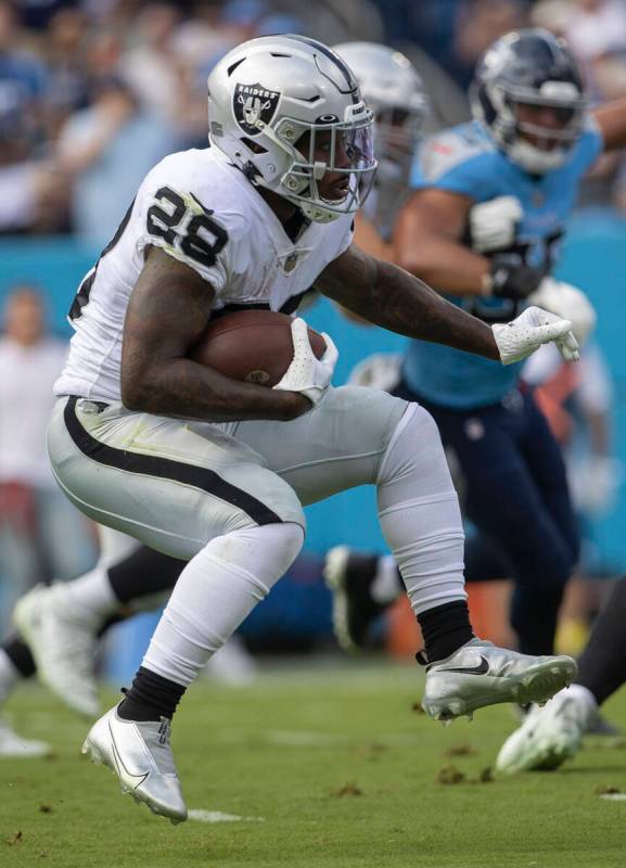 Raiders running back Josh Jacobs (28) looks for room to run during the first half of an NFL gam ...