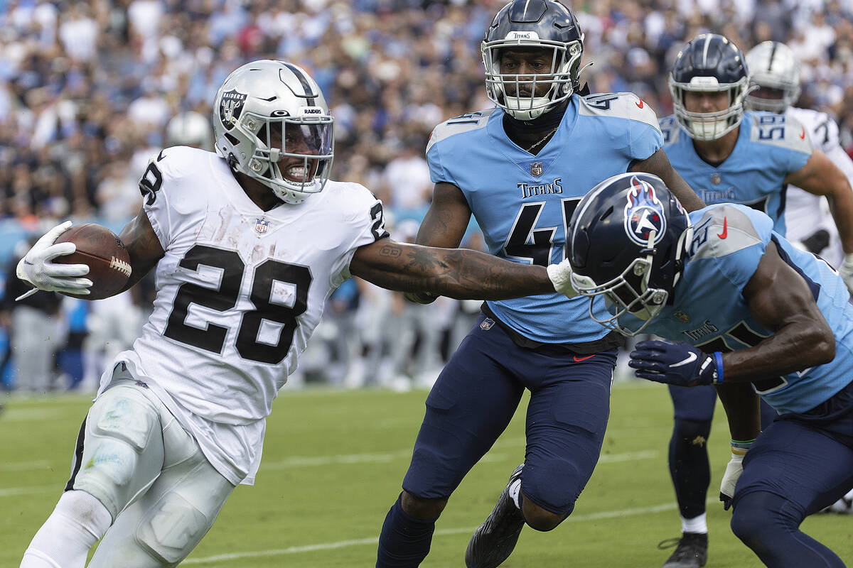 Raiders running back Josh Jacobs (28) stiff arms Tennessee Titans cornerback Roger McCreary (21 ...