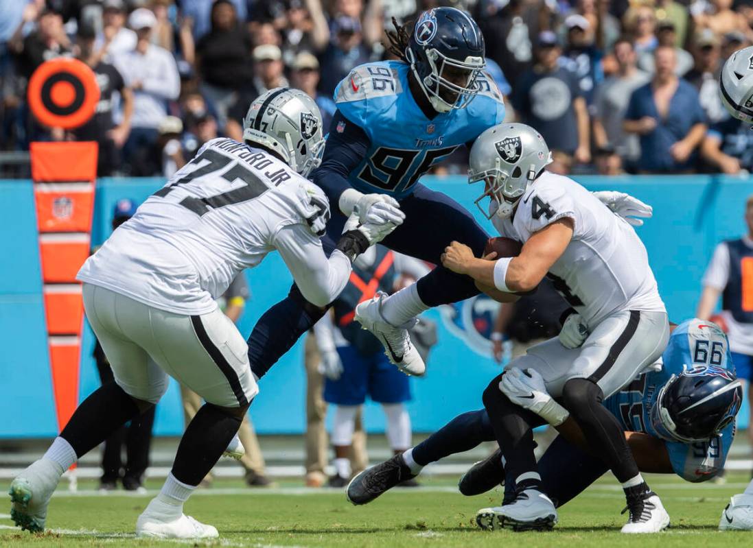 Raiders quarterback Derek Carr (4) is sacked by Tennessee Titans defensive end Denico Autry (96 ...
