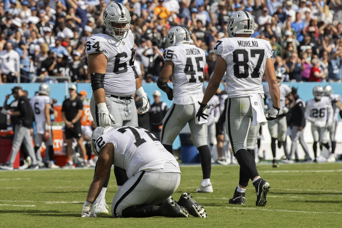 Raiders guard Alex Bars (64) consoles Raiders offensive lineman Jermaine Eluemunor (72) in the ...