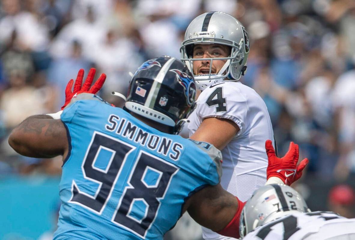 Raiders quarterback Derek Carr (4) looks to throw under pressure from Tennessee Titans defensiv ...