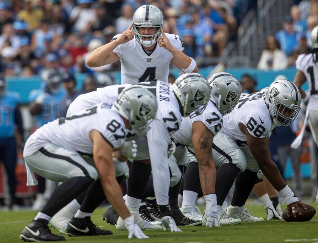 Raiders quarterback Derek Carr (4) calls a play on the line of scrimmage as tight end Foster Mo ...