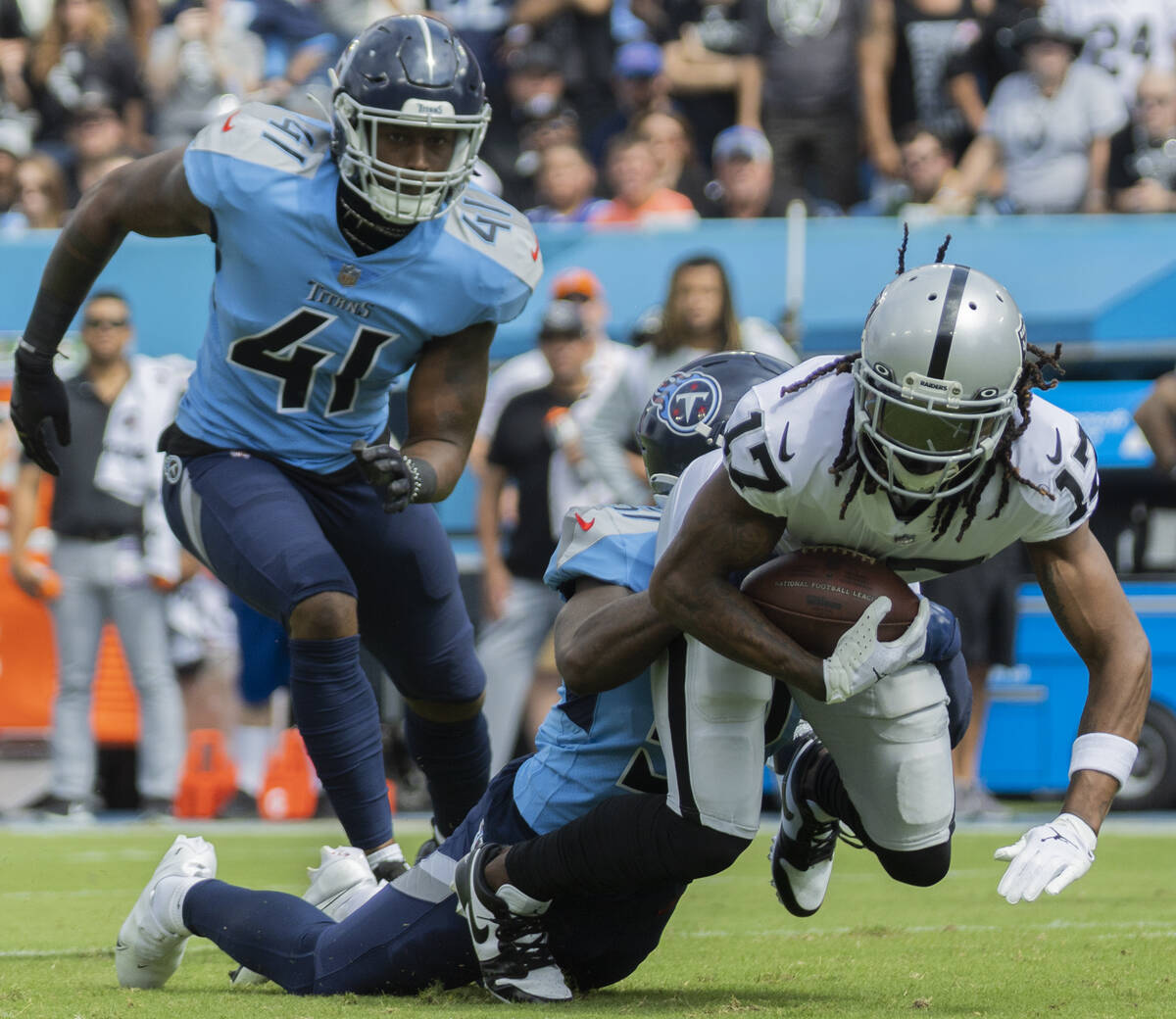 Raiders wide receiver Davante Adams (17) is tackled by Tennessee Titans linebacker Zach Cunning ...