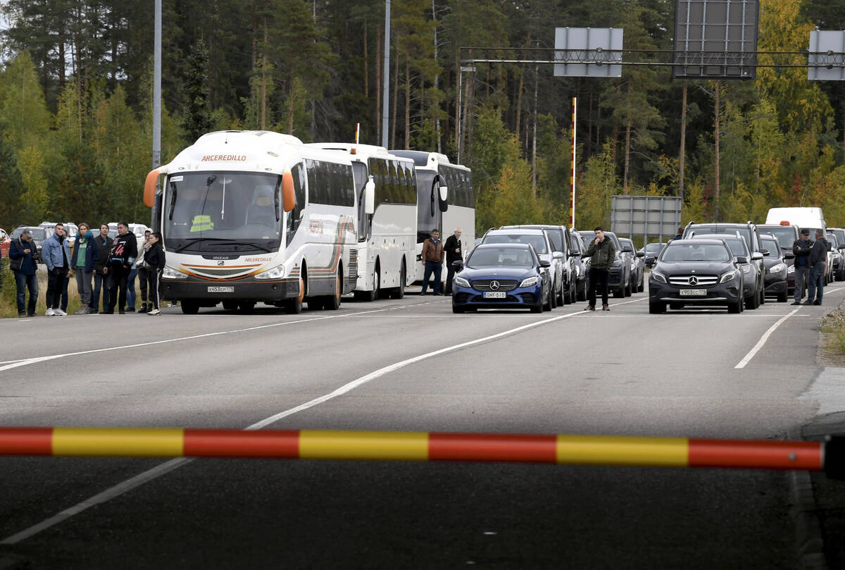 People traveling from Russia in cars and coaches queue to cross the border to Finland at the Va ...