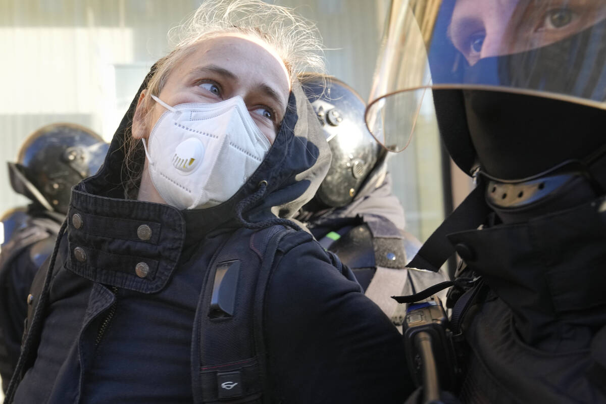 Russian policemen detain a demonstrator protesting against mobilization in St. Petersburg, Russ ...