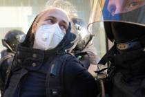 Russian policemen detain a demonstrator protesting against mobilization in St. Petersburg, Russ ...