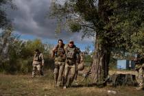 A Ukrainian serviceman helps a comrade during an evacuation of injured soldiers participating i ...