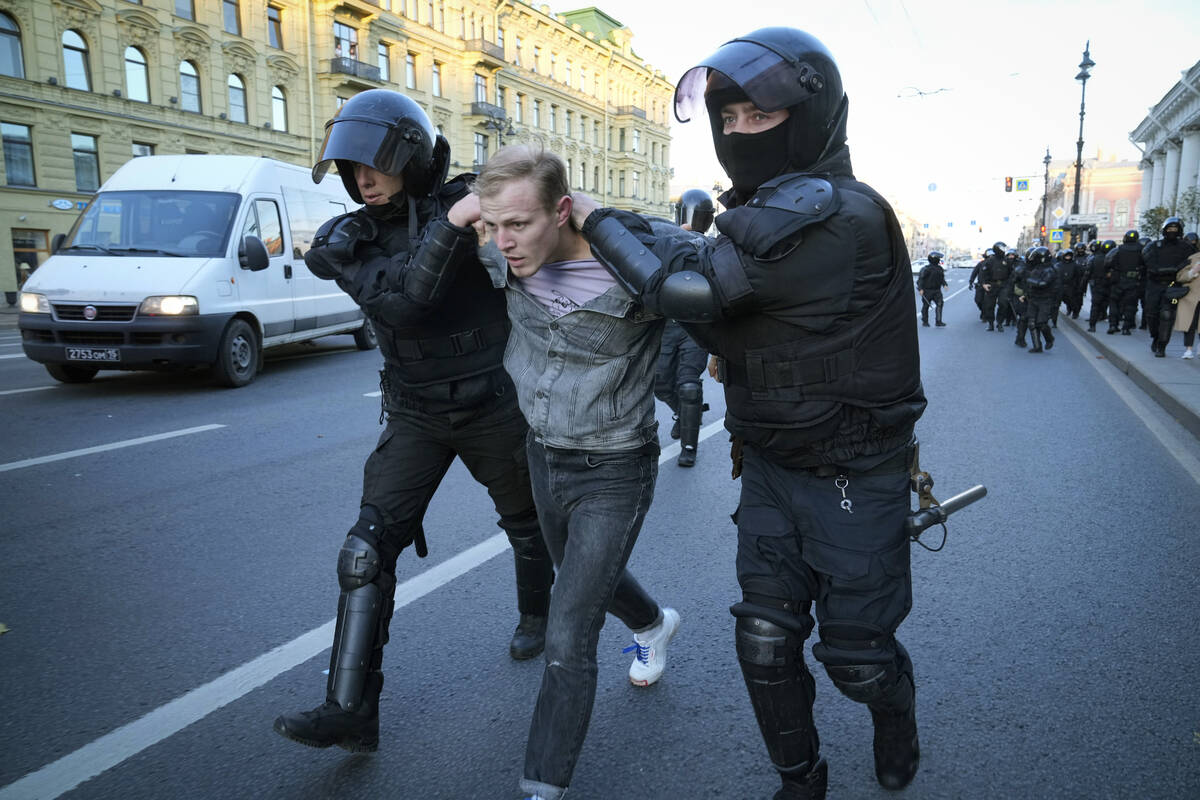 Russian policemen detain a demonstrator protesting against mobilization in St. Petersburg, Russ ...