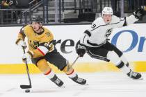 Golden Knights center Sakari Manninen (64) skates with the puck under pressure from Los Angeles ...