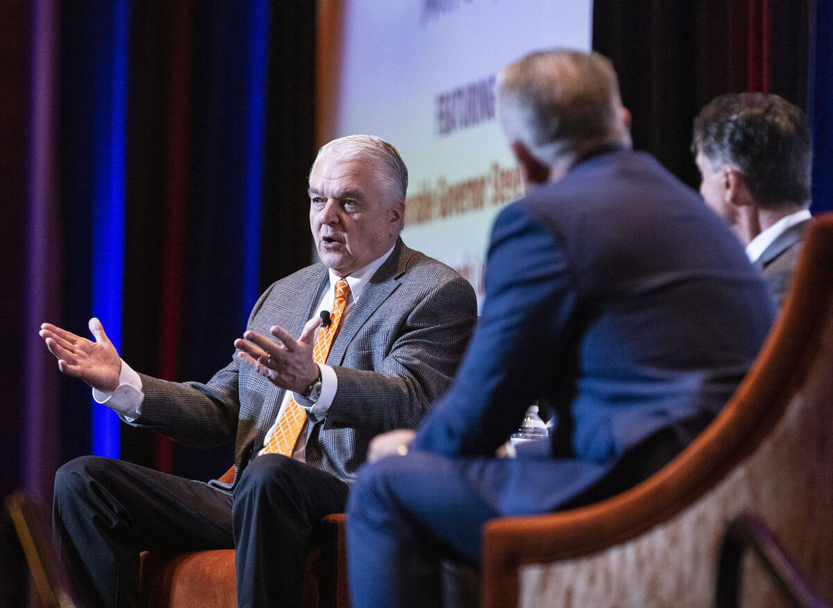 Gov. Steve Sisolak, left, speaks as moderator Mitch Fox, right, president and CEO of the Nevada ...