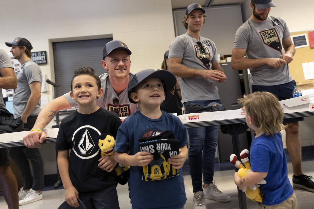 Silas Gillihan, 6, left, and Nixon Gillihan, 5, center, pose for a photo with Golden Knights ce ...