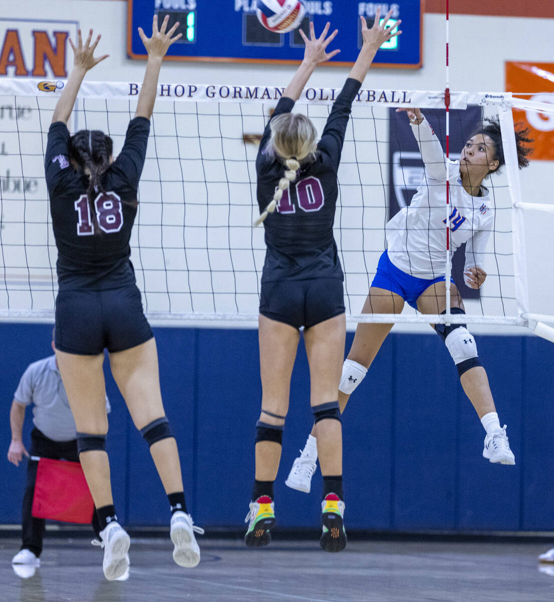 Bishop Gorman's Ayanna Wastson (14) spikes the ball past Faith Lutheran's Haylee Strong (18) an ...
