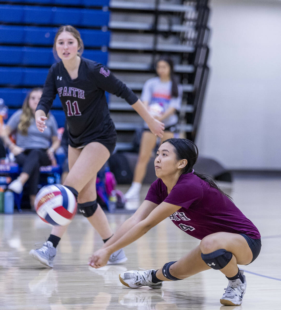 Faith Lutheran's Kayla Tran (4) digs the ball out as teammate Olivia Faulis (11) looks on versu ...