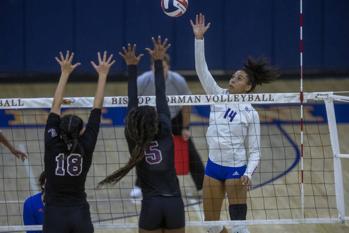 Ayanna Wastson dari Uskup Gorman (14) mengoper bola ke Italya Cloyd dari Faith Lutheran (5) dan ...