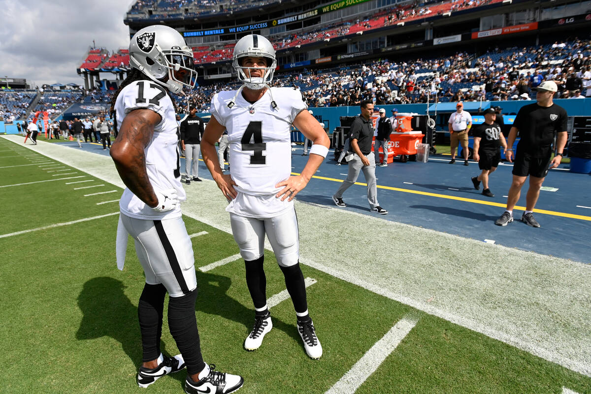 Las Vegas Raiders quarterback Derek Carr (4) talks with wide receiver Davante Adams (17) before ...