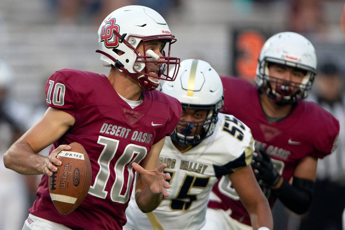 Desert Oasis quarterback Tyler Stott (10) looks to pass while Spring Valley offensive lineman T ...