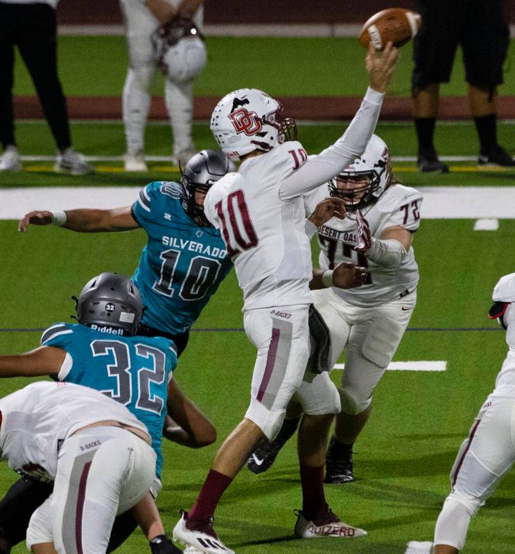 Desert Oasis quarterback Tyler Stott (10) throws under pressure from Silverado High’s ti ...