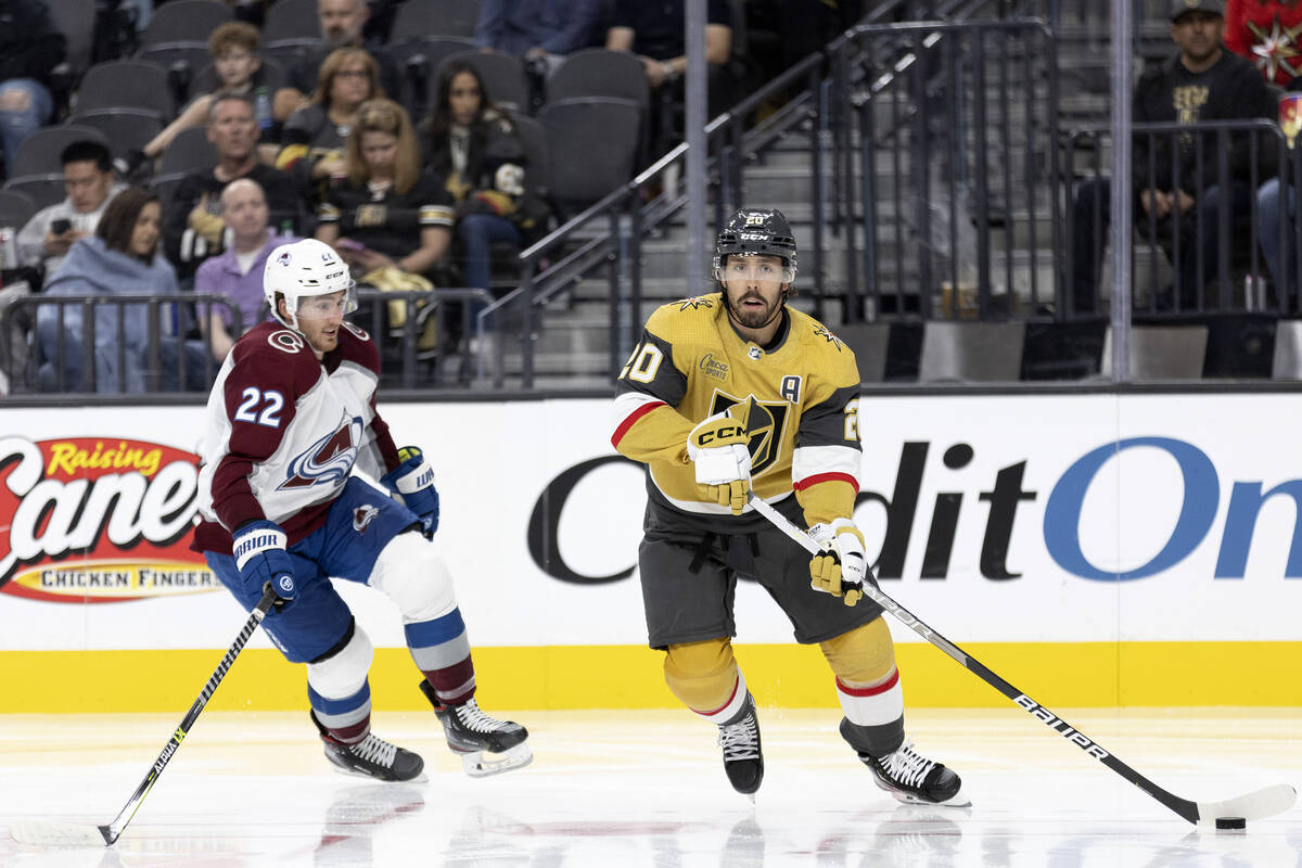 Golden Knights center Chandler Stephenson (20) skates with the puck alongside Avalanche center ...