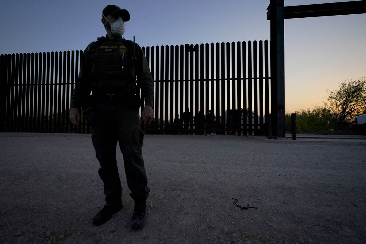 FILE - In this March 21, 2021 file photo, a U.S. Customs and Border Protection agent looks on n ...