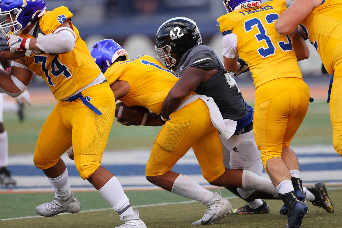 Orem's Chase Tuatagaloa (1) is sacked by Desert Pines' Idgerinn Dean (42) in the second quarter ...