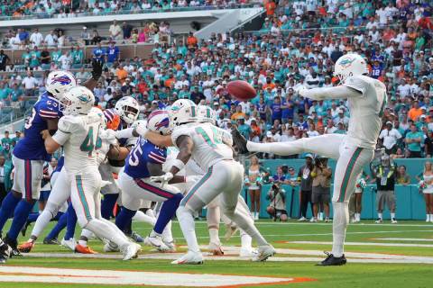 Miami Dolphins punter Thomas Morstead (4) punts the ball into the back of Miami Dolphins wide r ...