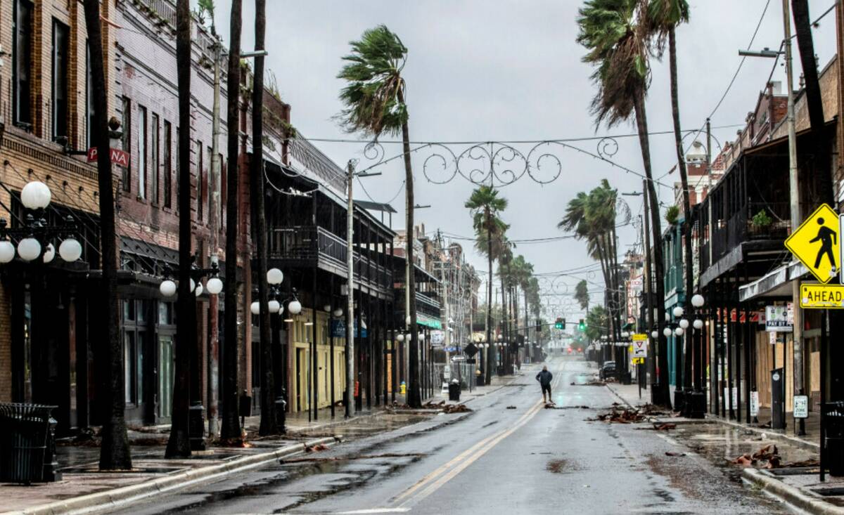 A man stands in the middle 7th Street in Ybor City on the rains soaked streets, a few hours bef ...
