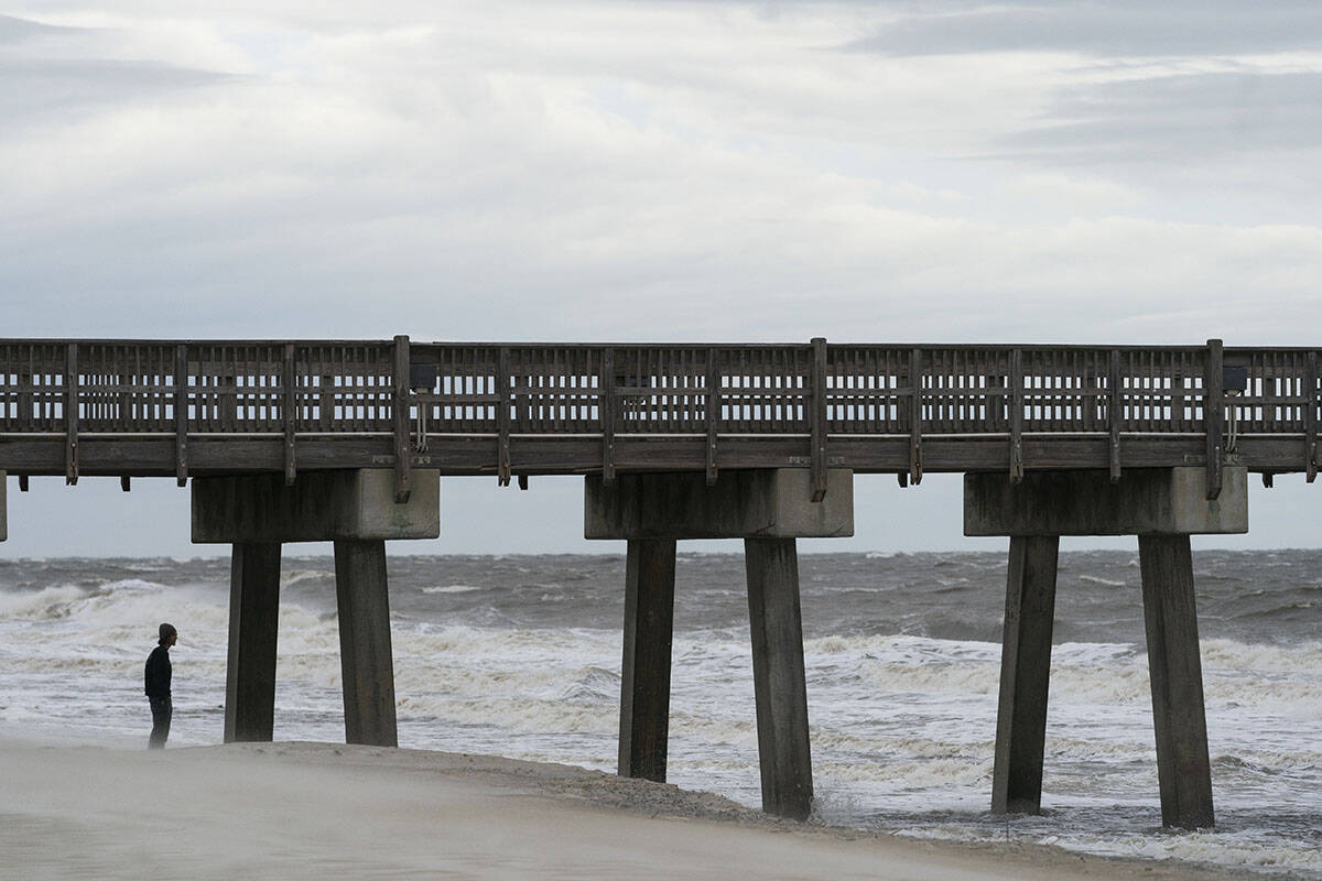 Alex Tatlock, from Savannah, Ga., checks out the surf, and decides against surfing, as the effe ...