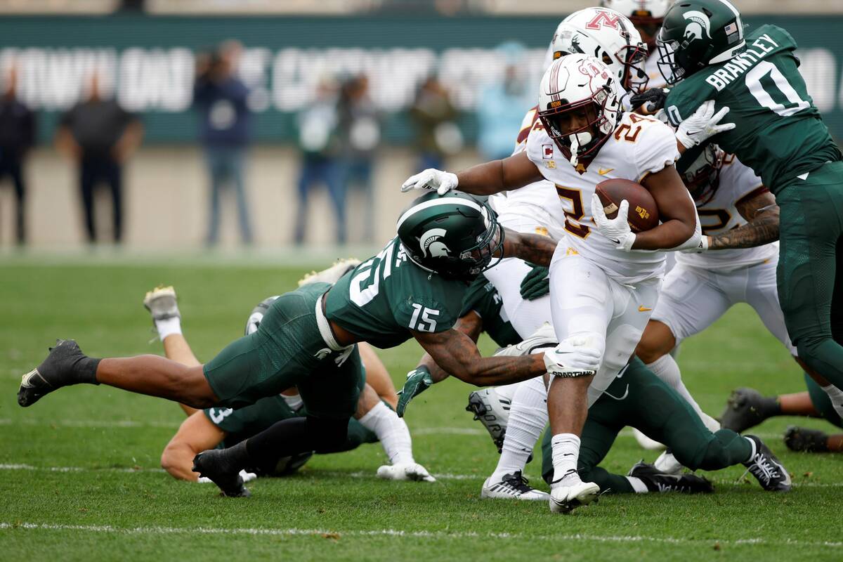 Minnesota's Mohamed Ibrahim (24) rushes against Michigan State's Angelo Grose (15) during the f ...