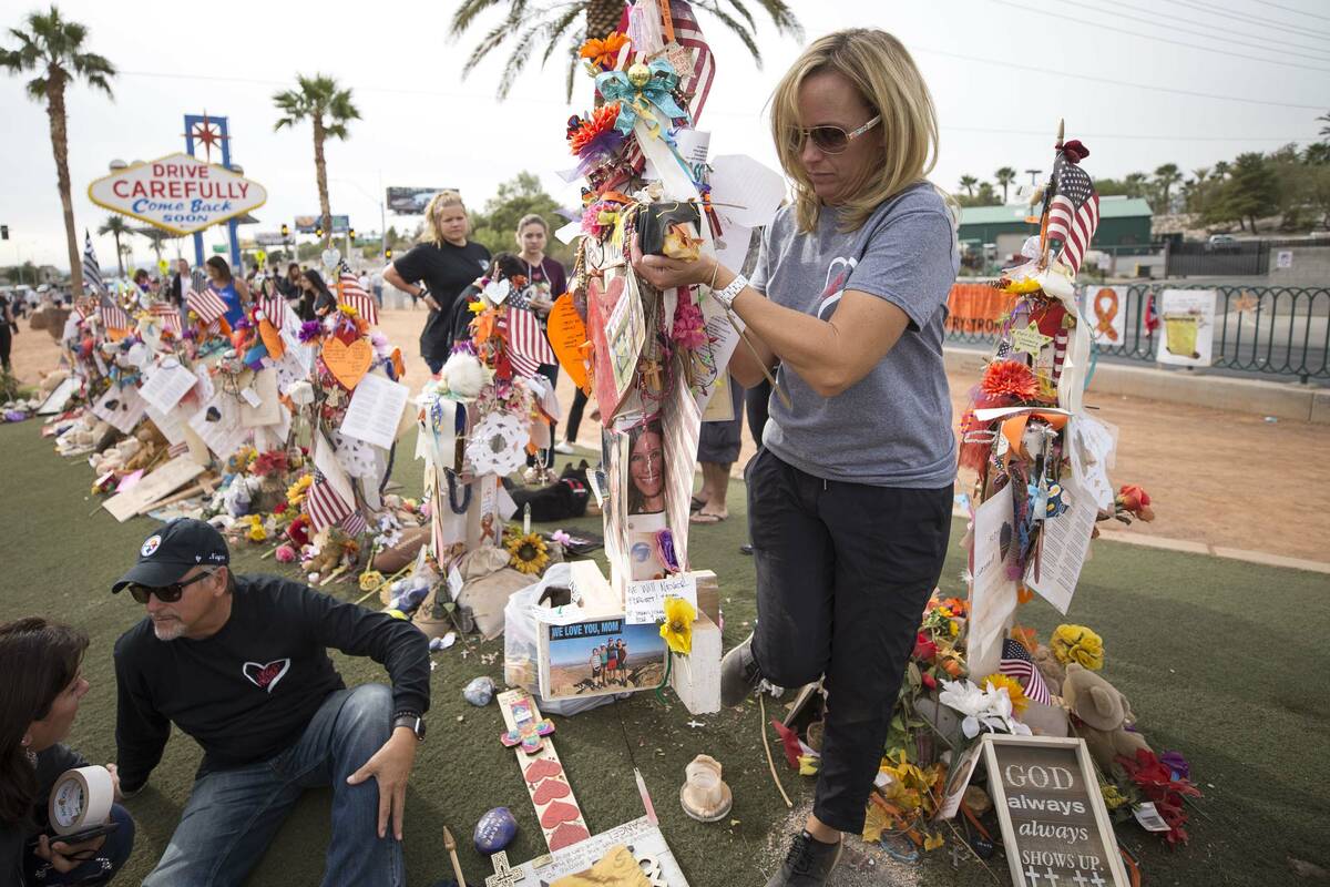 Mynda Smith, sister of Route 91 victim Neysa Tonks, helps move her sister's cross following a c ...
